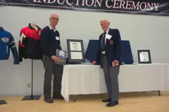 man handing award to another man